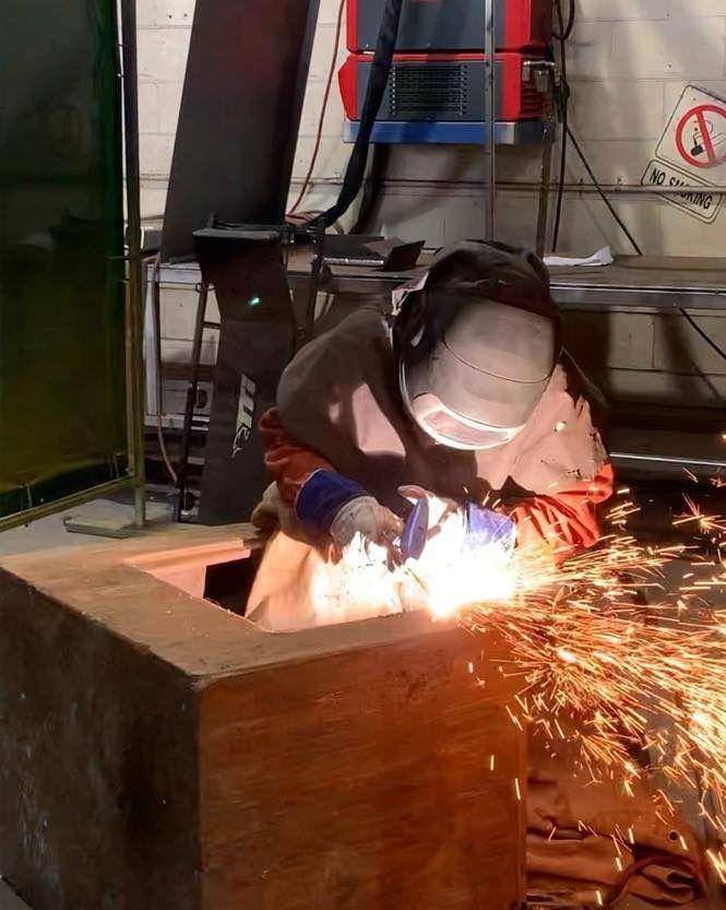 A Man Is Welding A Piece Of Metal In A Factory — Hanby Welding & Engineering In Portsmith, QLD