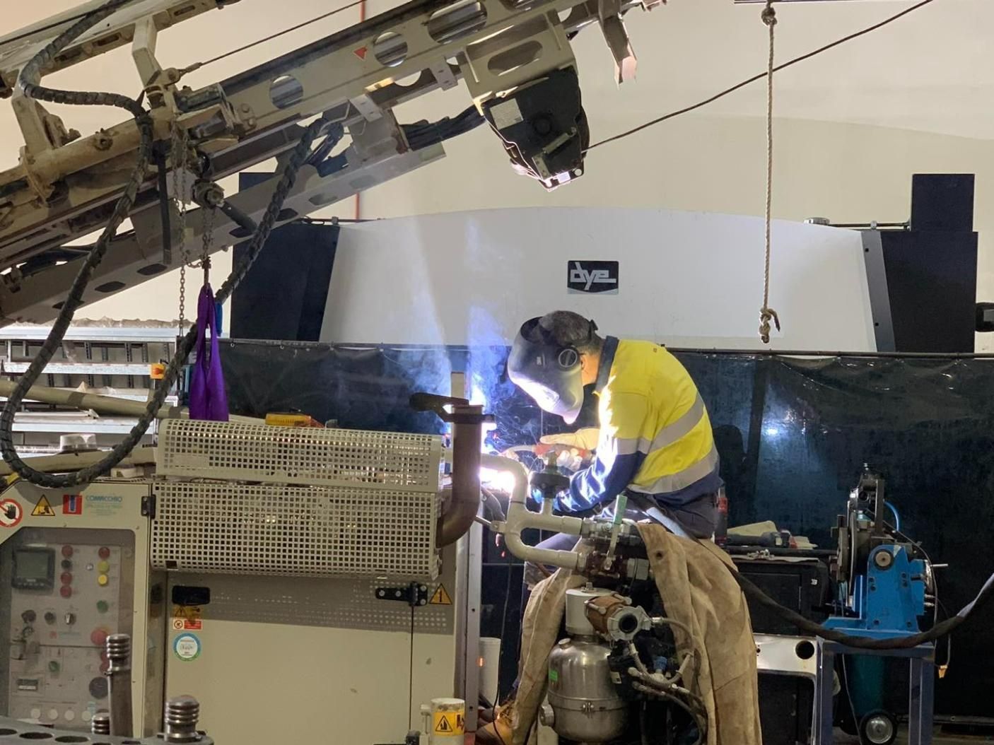 A Man Is Welding A Pipe In A Factory — Hanby Welding & Engineering In Portsmith, QLD