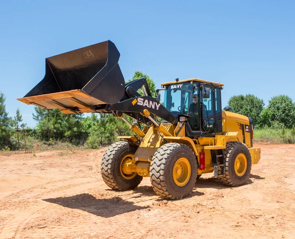 Yellow SANY wheel loader on dirt; a clear blue sky in the background.