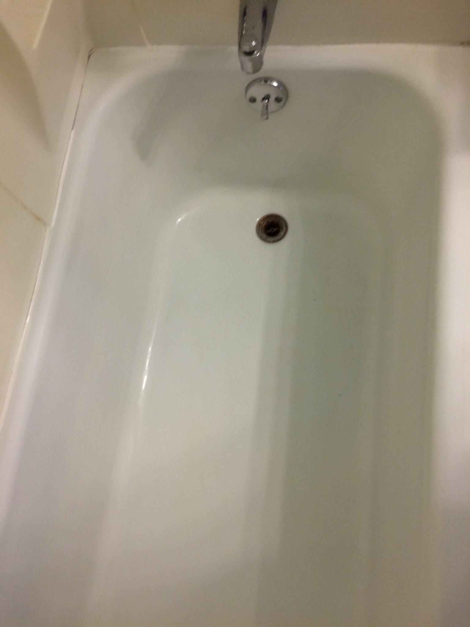 A white bathtub with a chrome faucet in a bathroom.