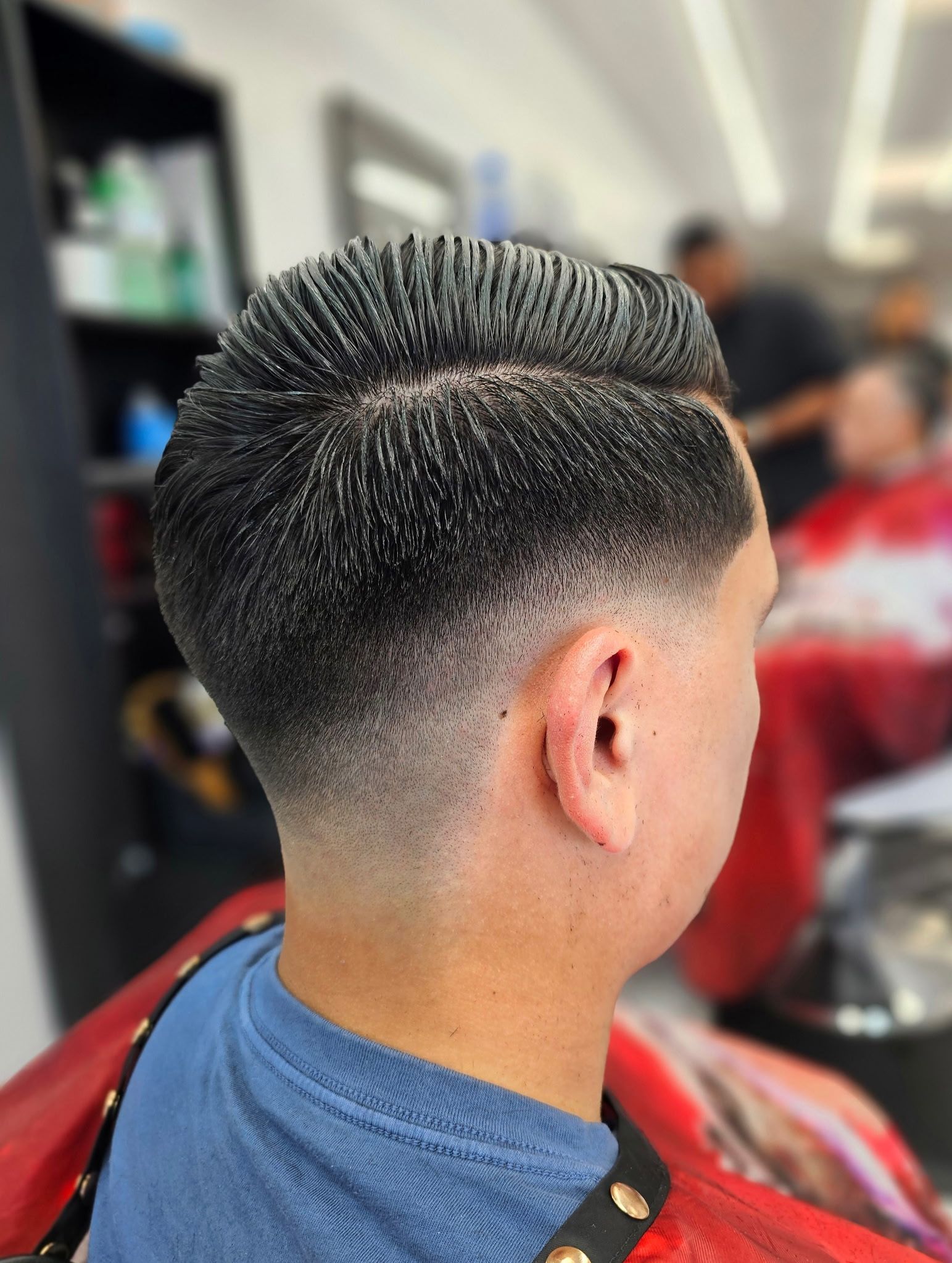 A close-up view of a precision haircut featuring a sharp skin fade on the sides with textured hair styled on top.