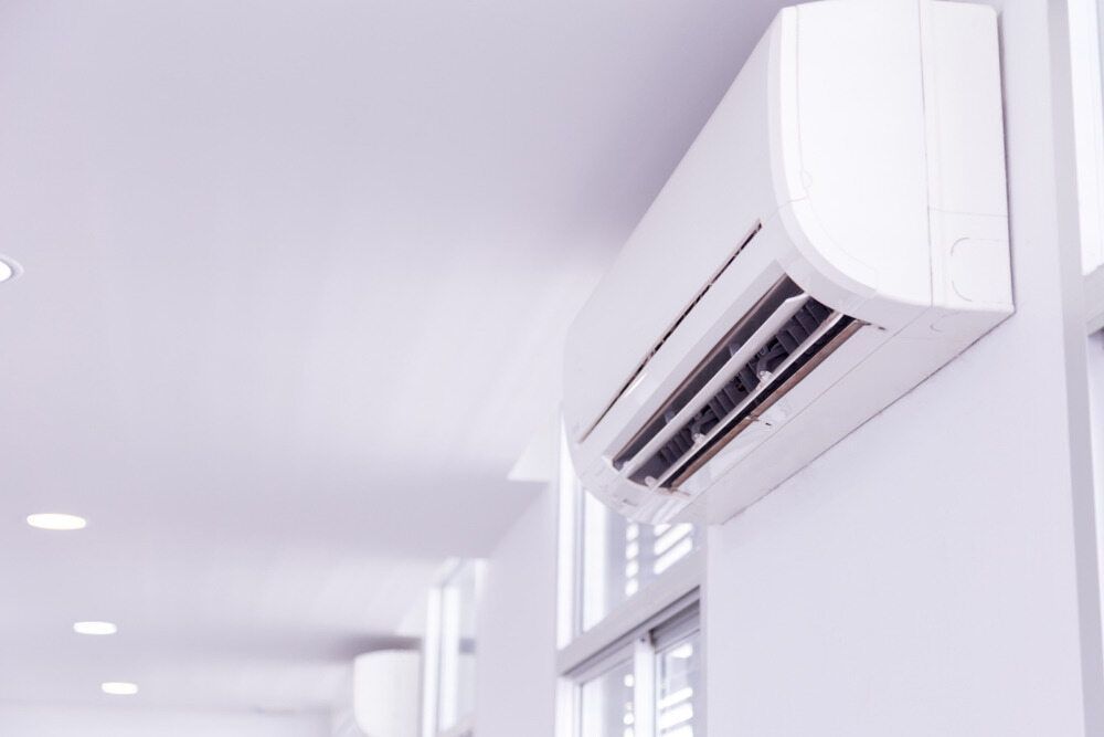 A White Air Conditioner Is Hanging On A White Wall In A Hallway — Coolmech In Gympie, QLD