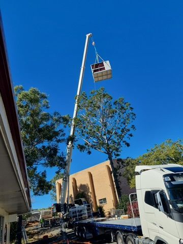 Crane Lifting A Large Air Change Commercial Air Conditioning Unit Into Place — Coolmech In Gympie, QLD