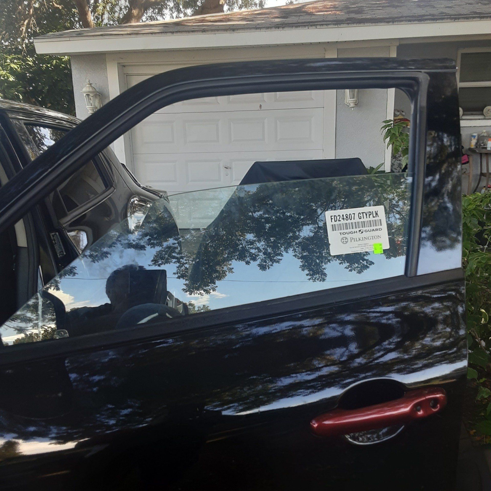 A black car is parked in front of a garage door