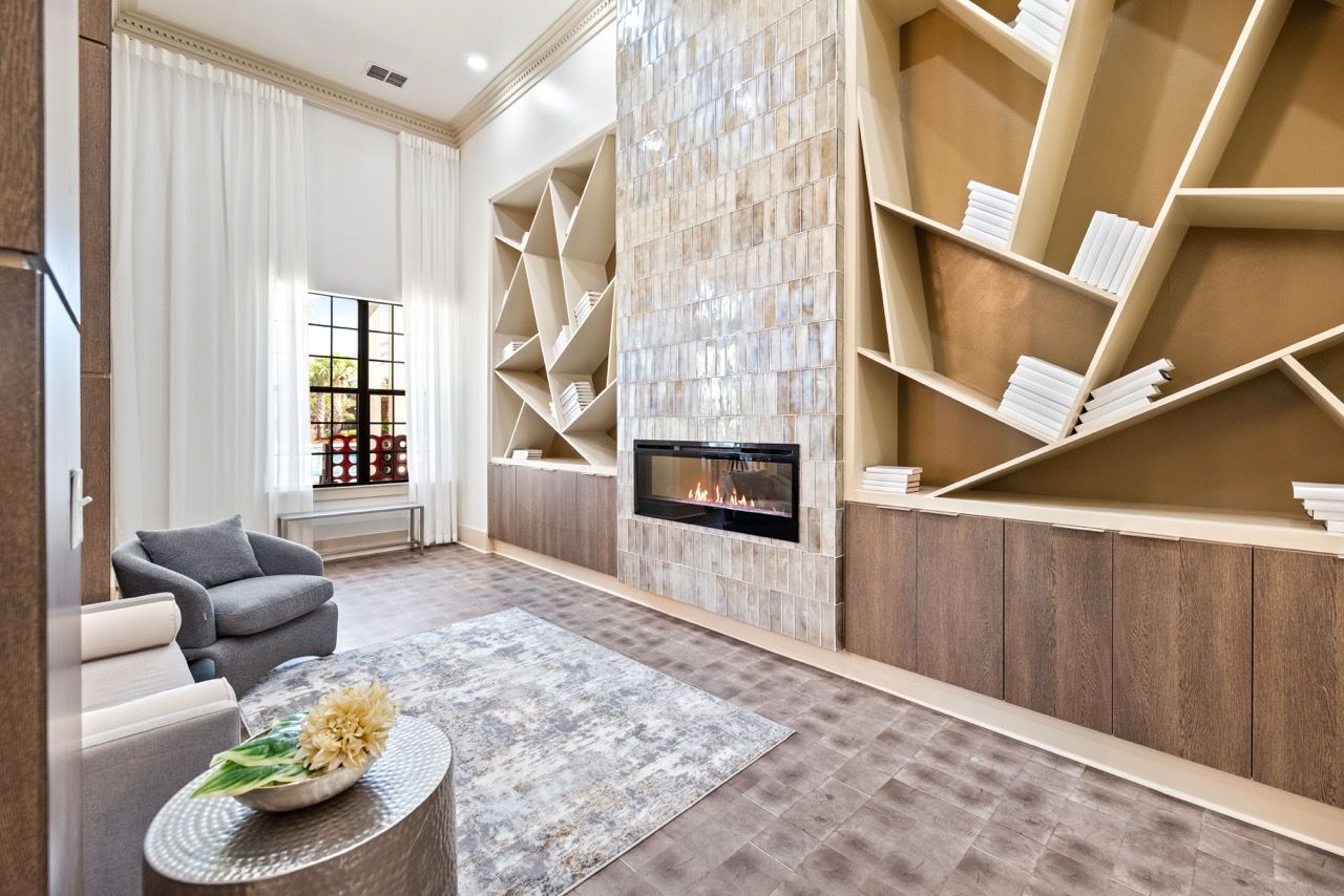 Modern apartment living room with a tiled fireplace, geometric shelves, and a large window.