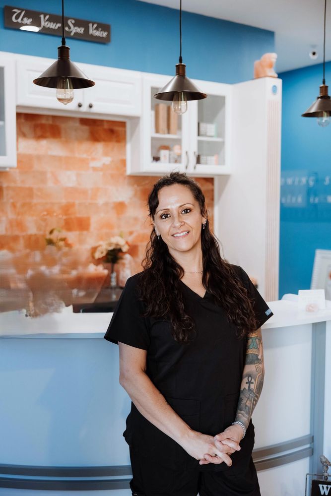 People in a hot tub at night, under string lights. Rain falls, blurring the scene.