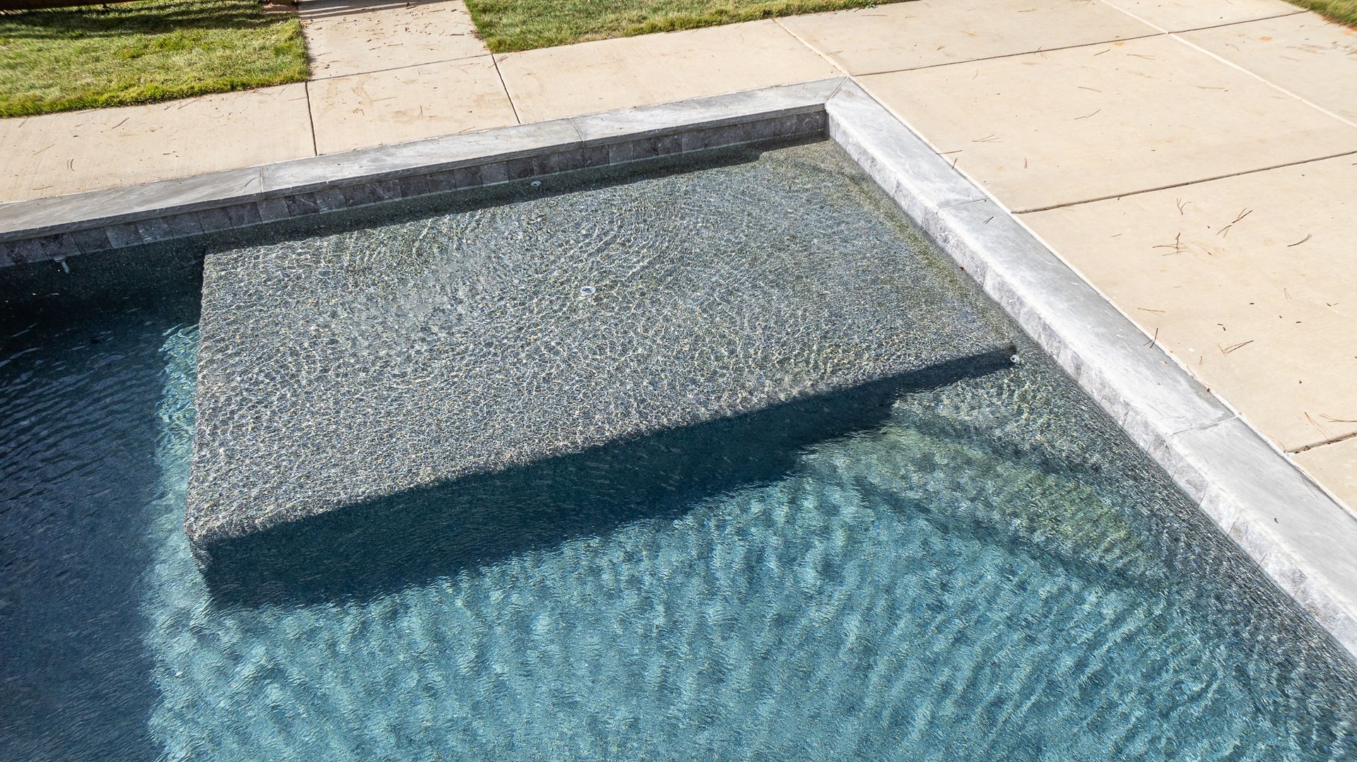 A close up of a swimming pool with steps leading into it.