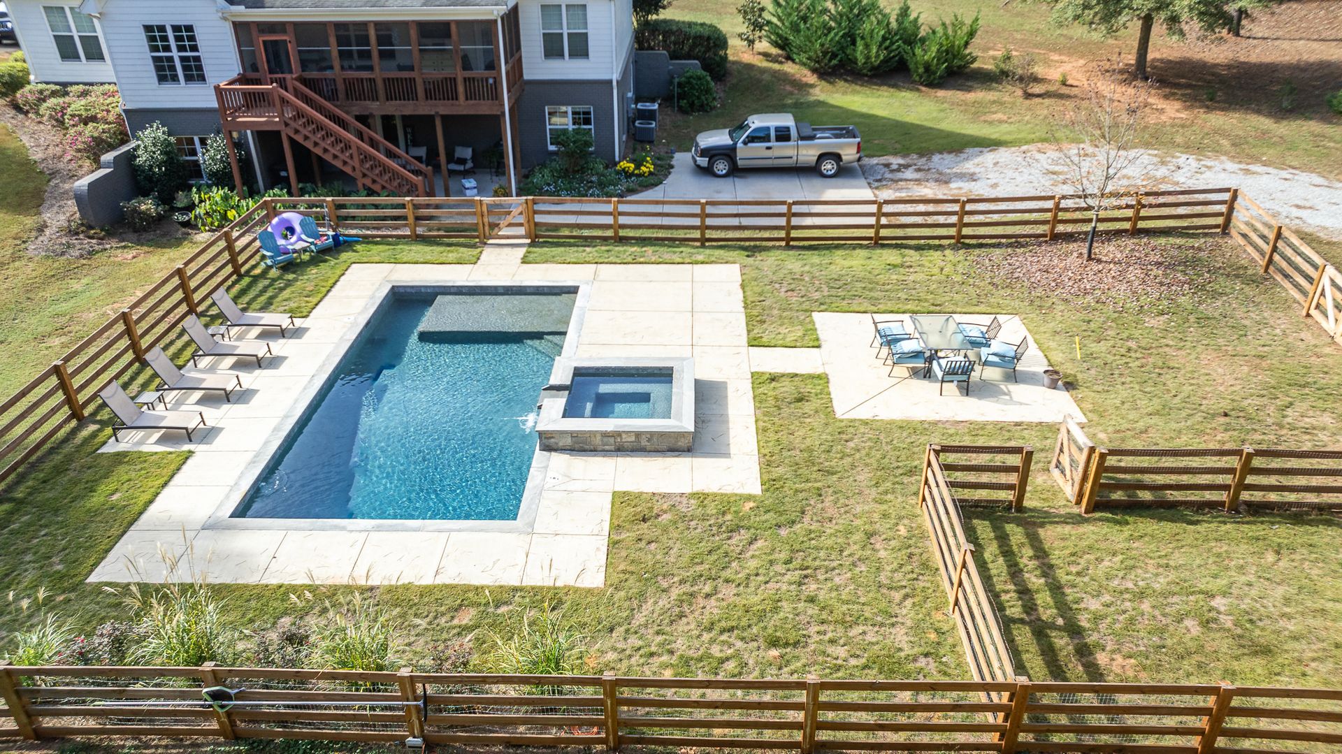 An aerial view of a large swimming pool surrounded by a wooden fence.