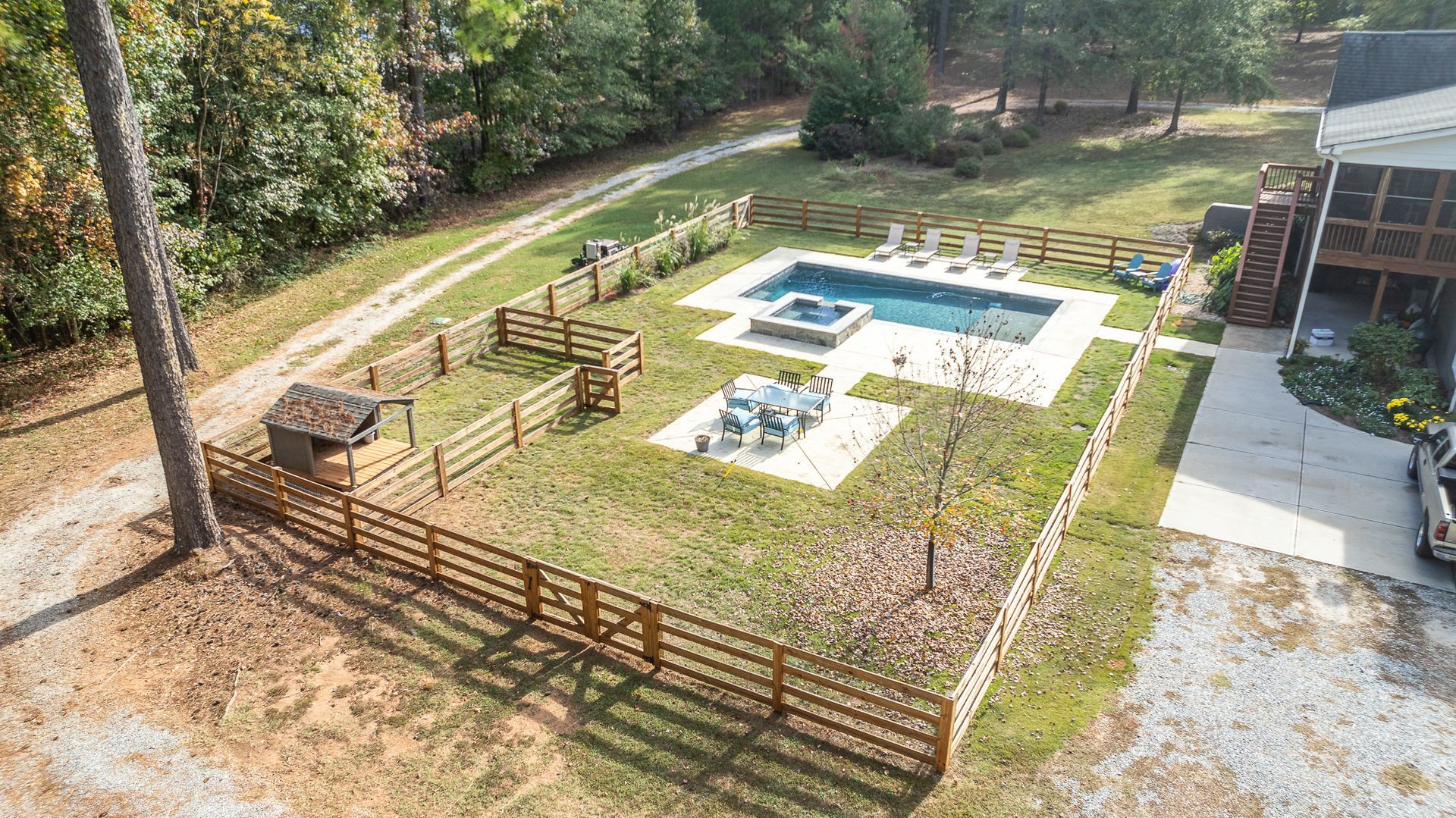 An aerial view of a house with a large swimming pool in the backyard.