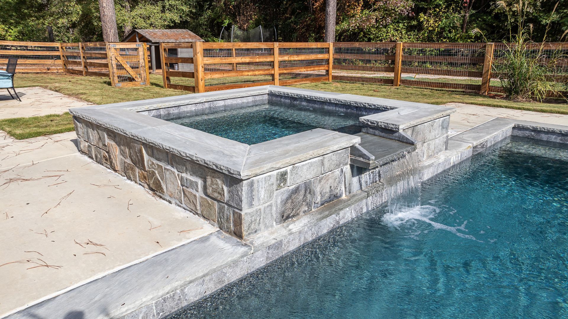 A swimming pool with a hot tub in the middle of it.