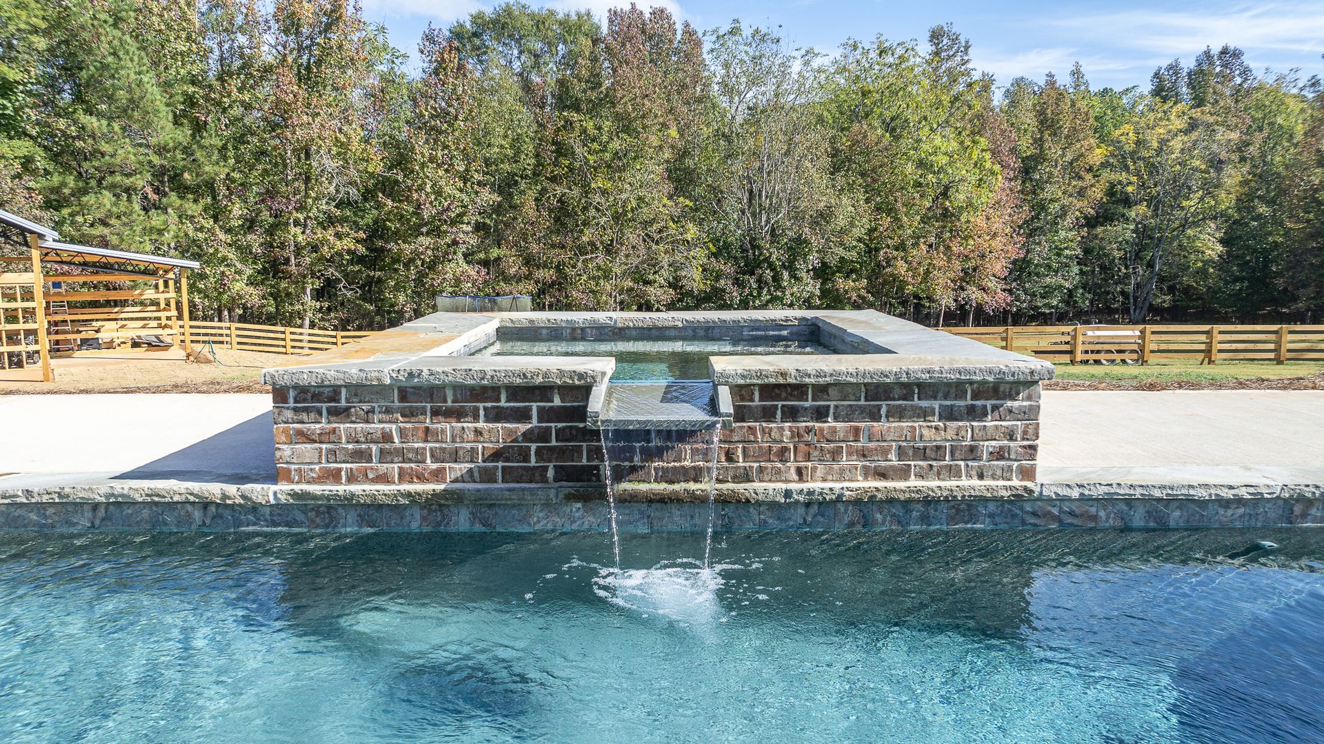 A swimming pool with a waterfall in the middle of it.