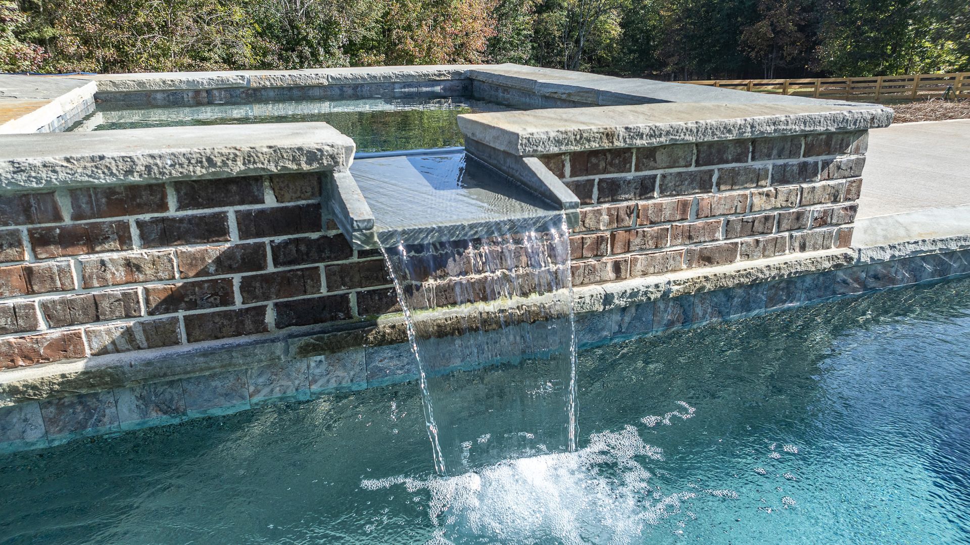 A swimming pool with a waterfall in the middle of it