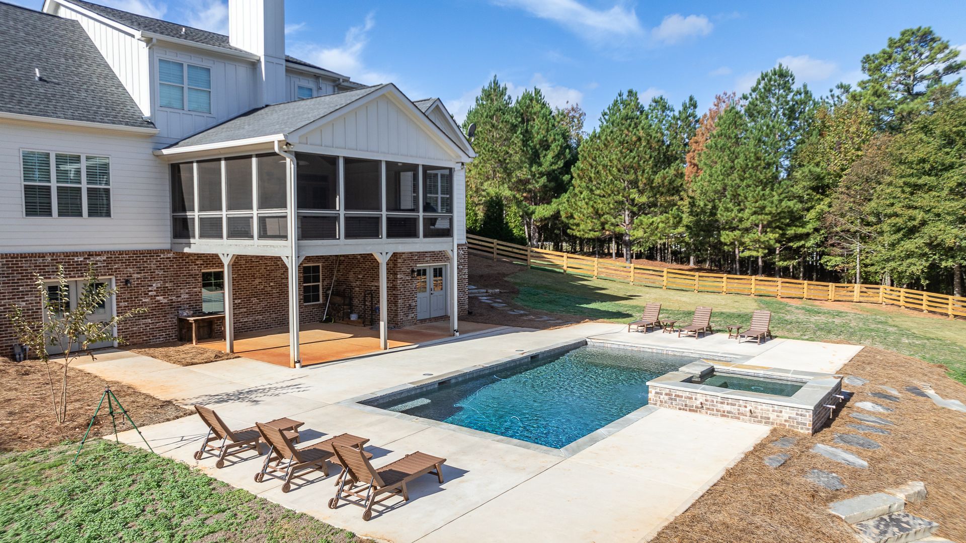 A large house with a screened in porch and a large swimming pool.