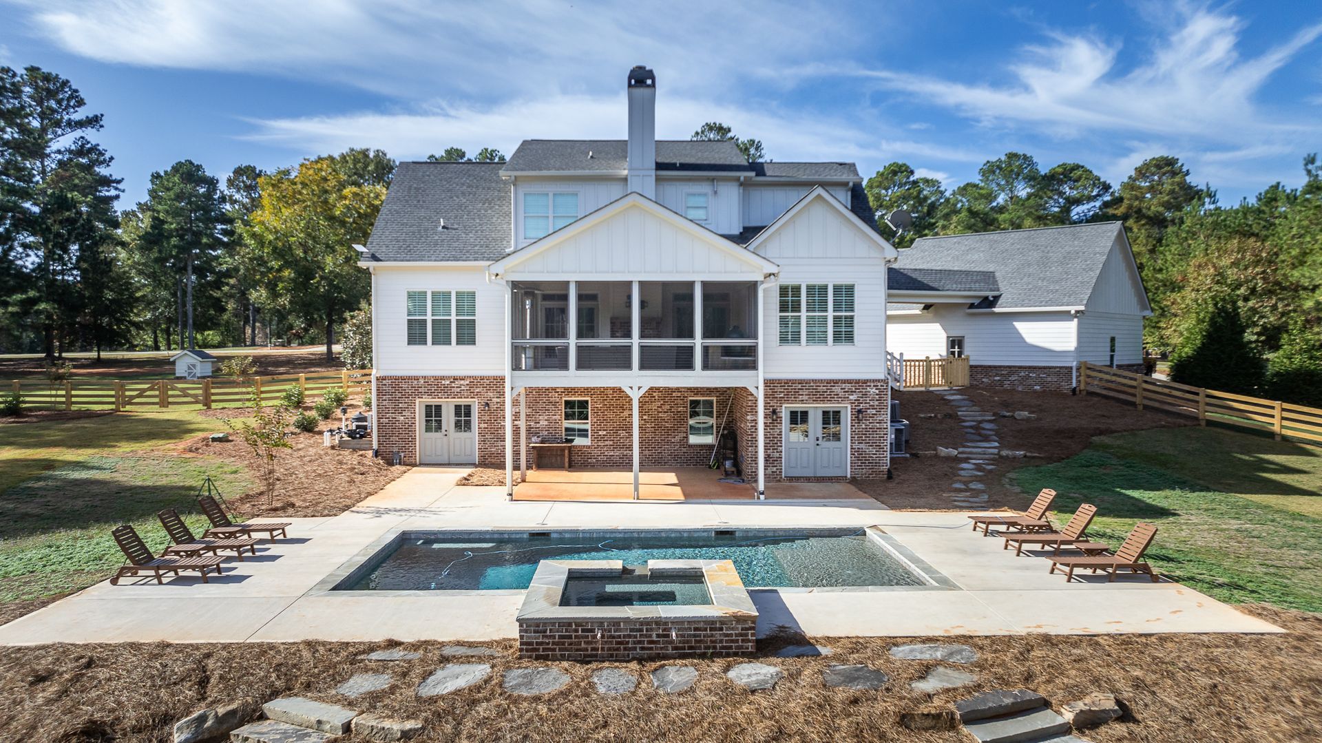 A large white house with a large swimming pool in front of it.