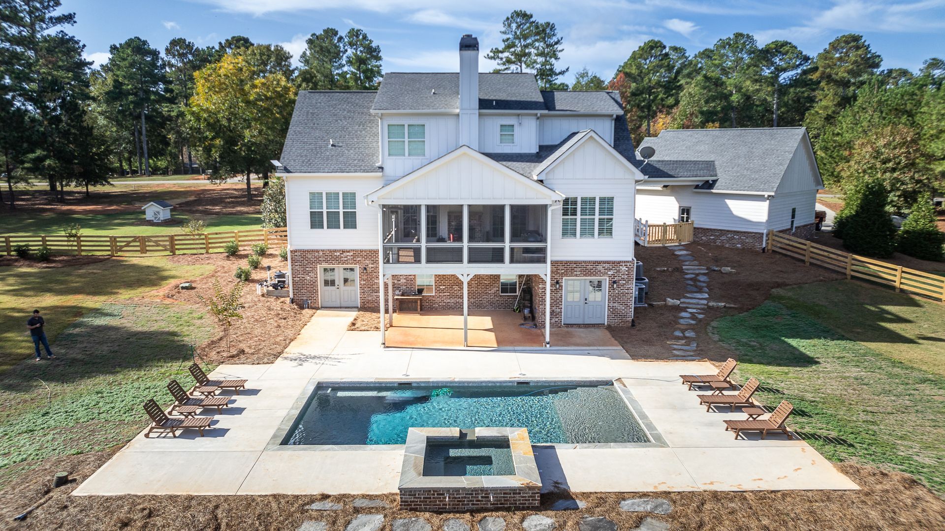 An aerial view of a house with a large swimming pool