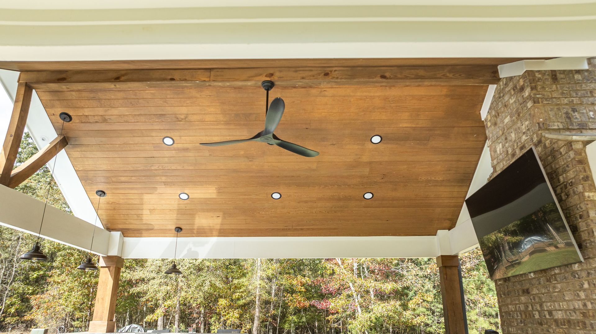 A wooden ceiling with a ceiling fan hanging from it.