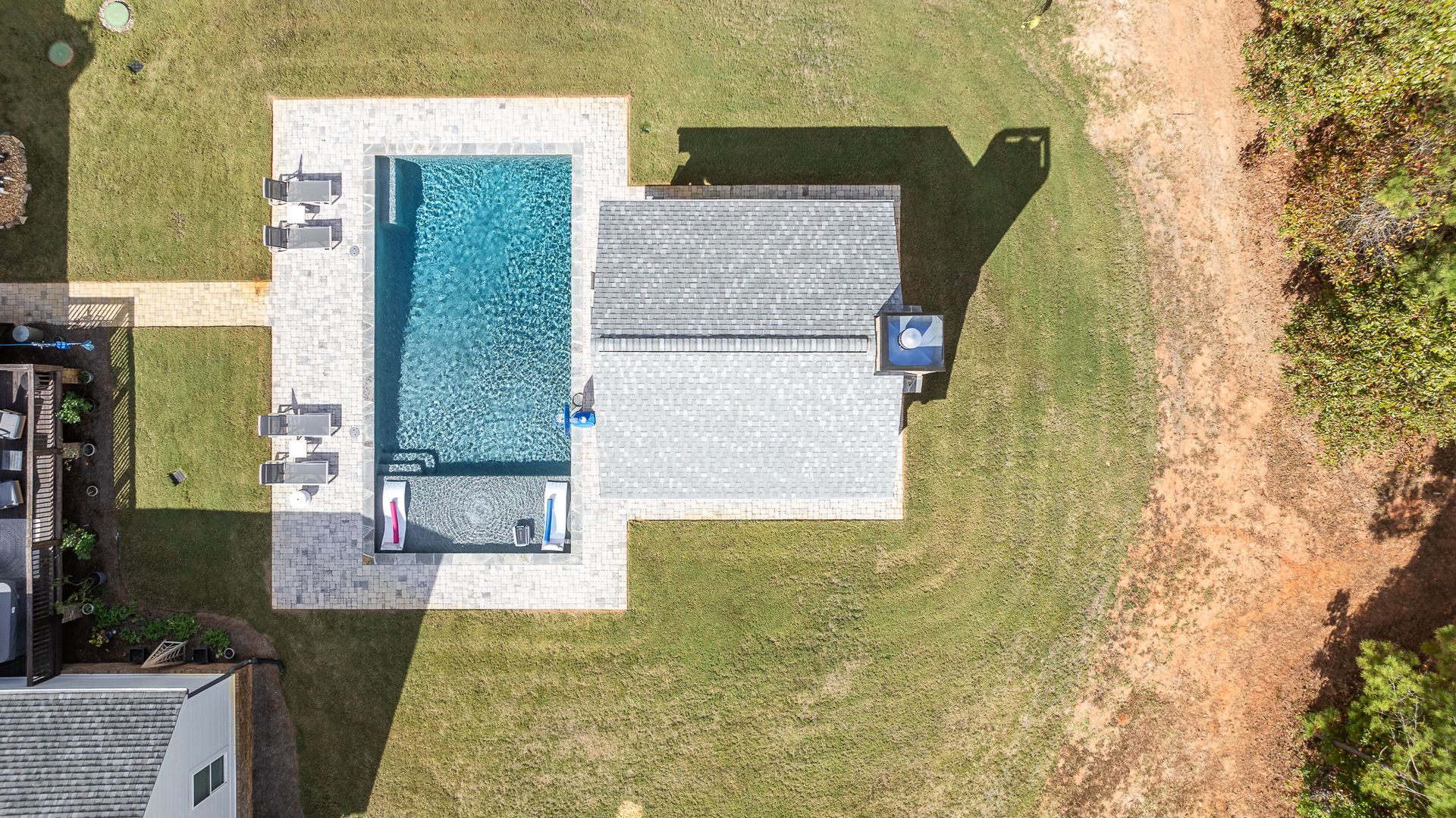 An aerial view of a house with a large swimming pool in the backyard.