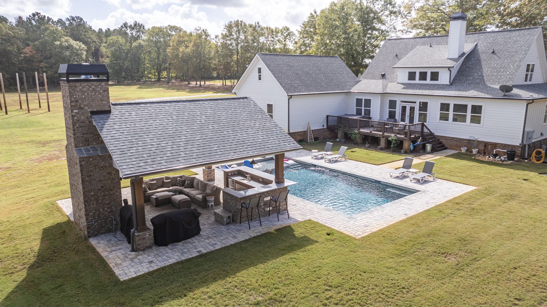 An aerial view of a large house with a swimming pool in the backyard.