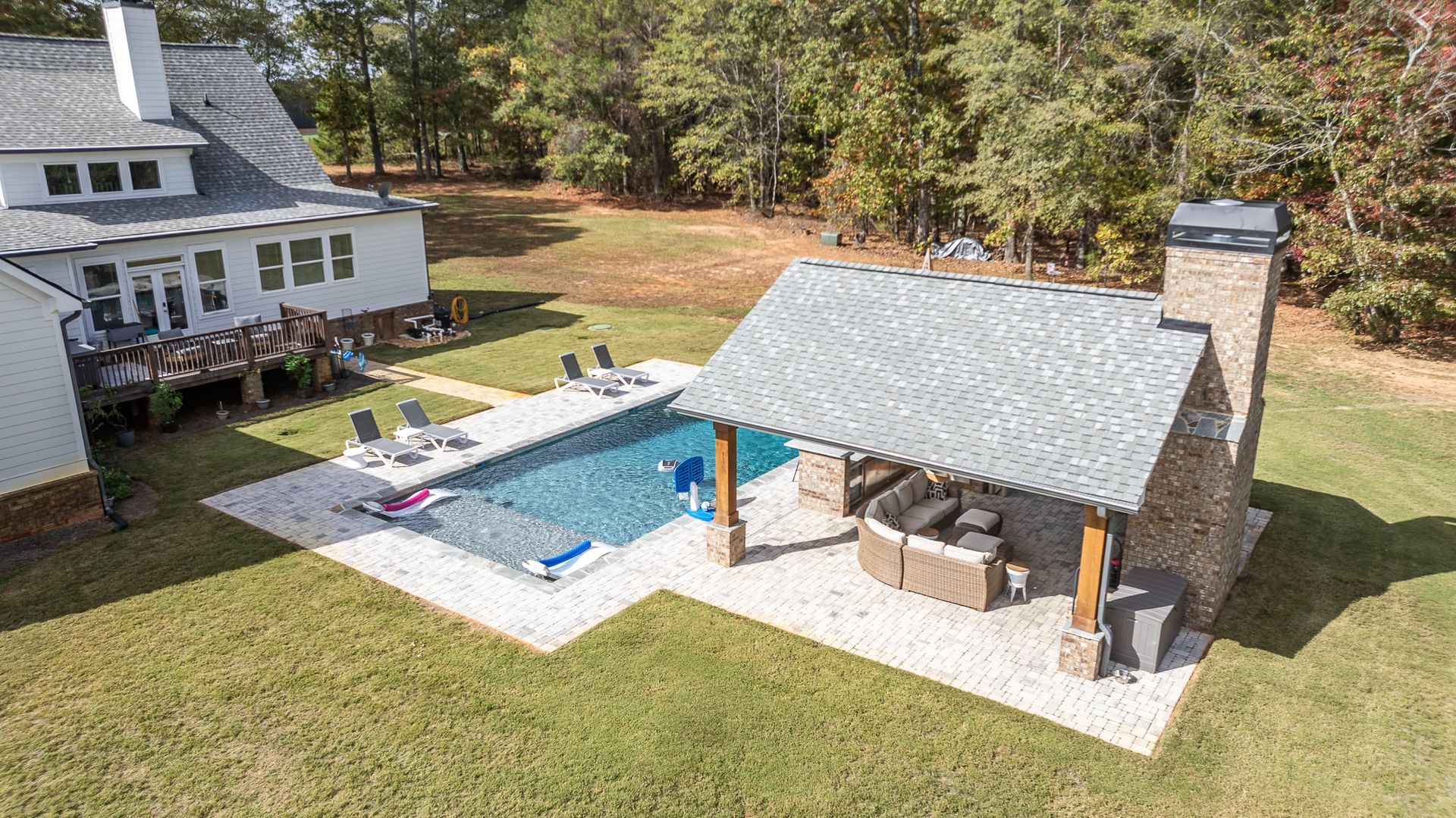 An aerial view of a house with a swimming pool and a pavilion.