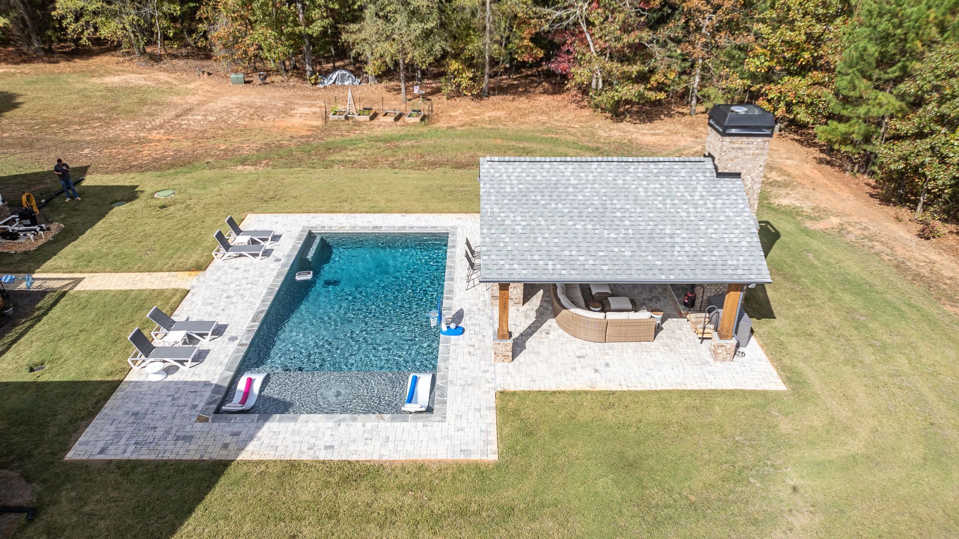 An aerial view of a large swimming pool with a gazebo in the backyard.