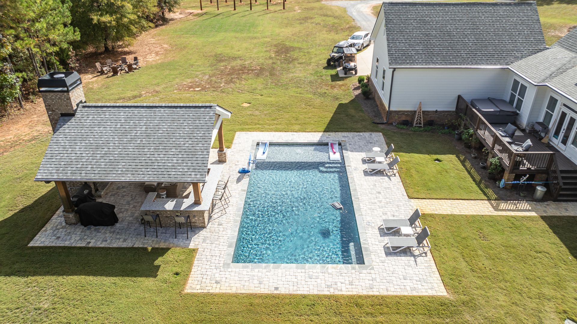 An aerial view of a house with a large swimming pool in the backyard.
