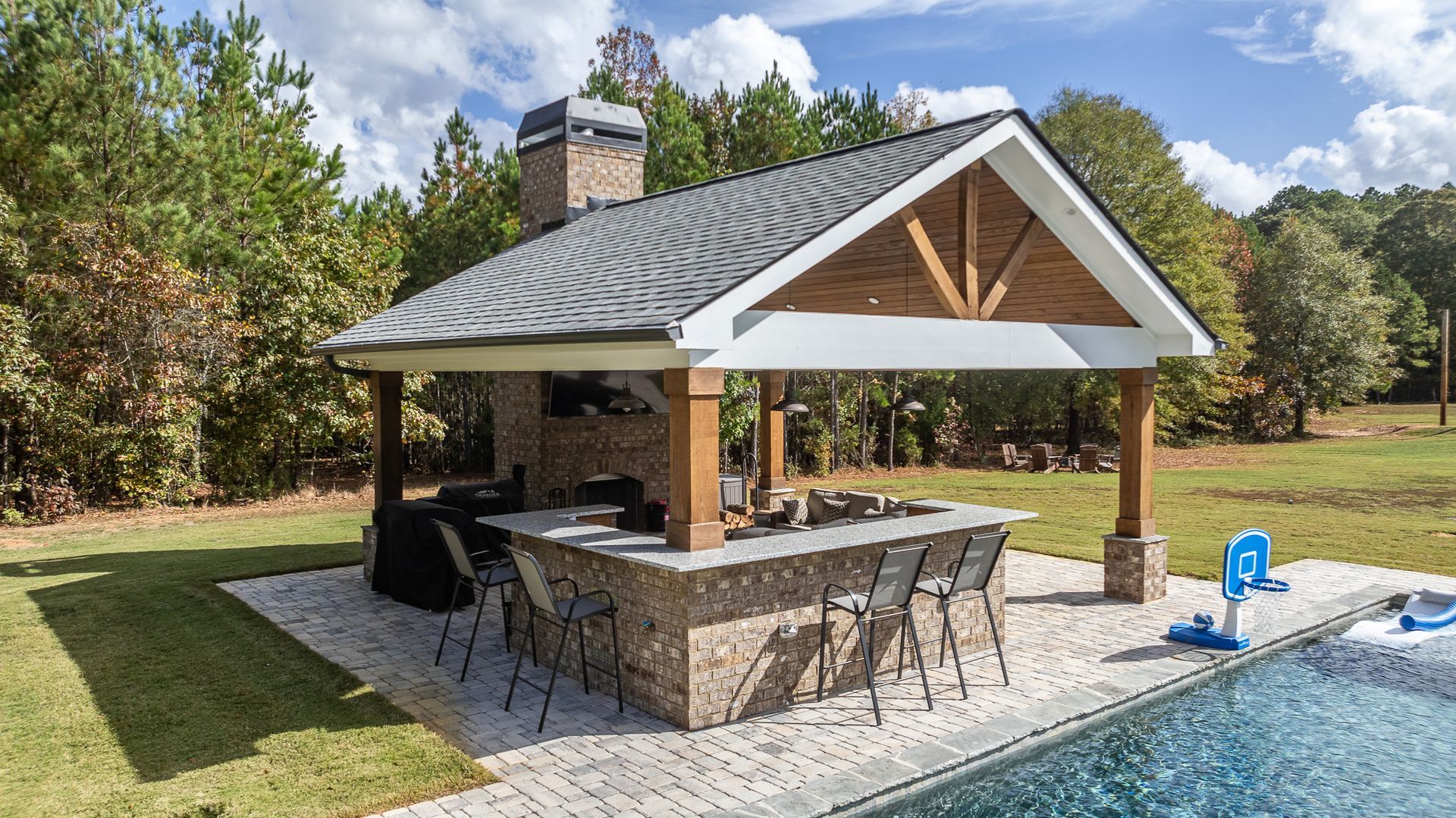 A patio area with a pavilion and a swimming pool in the backyard.