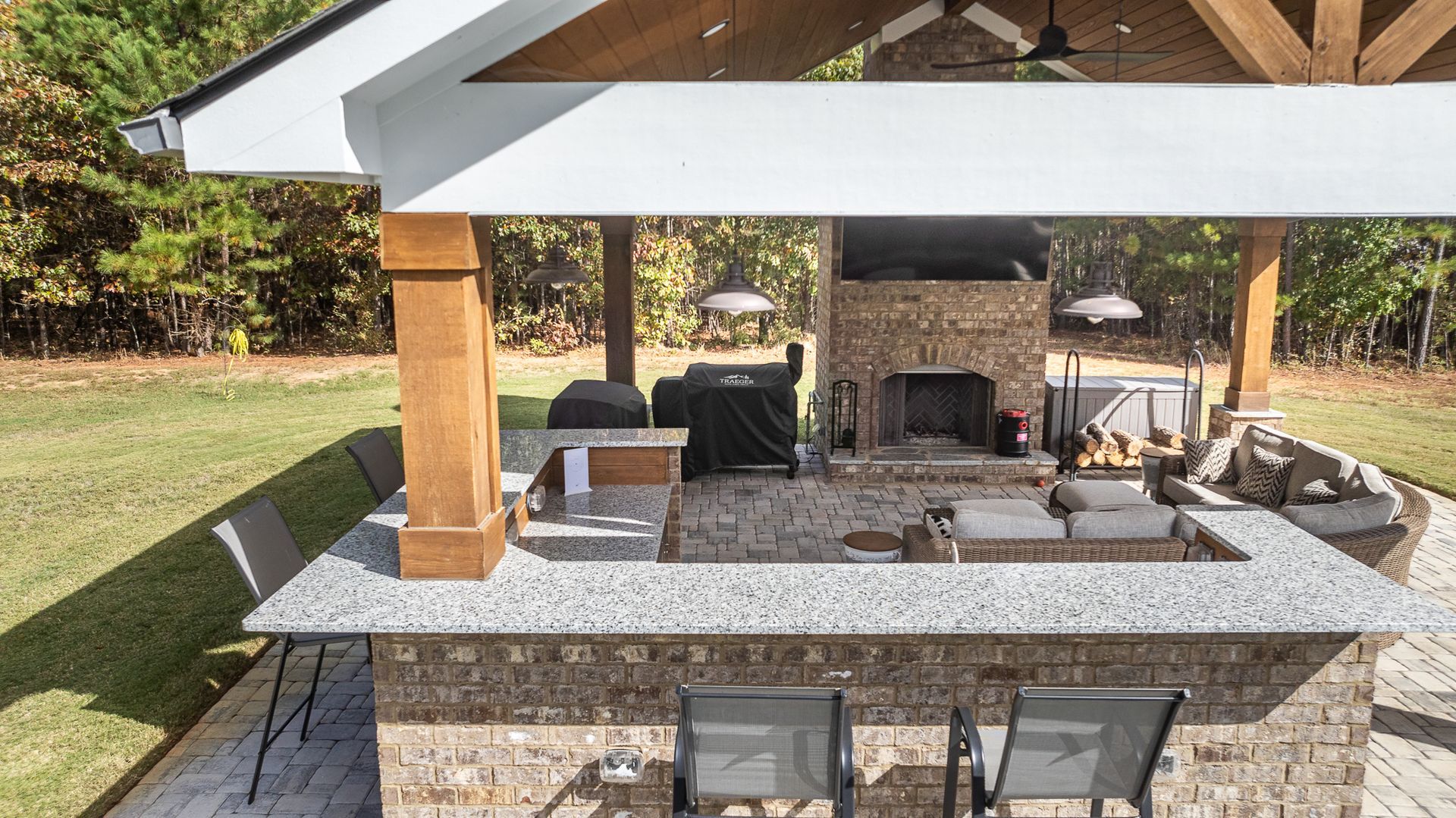A large outdoor kitchen with a fireplace and a grill.