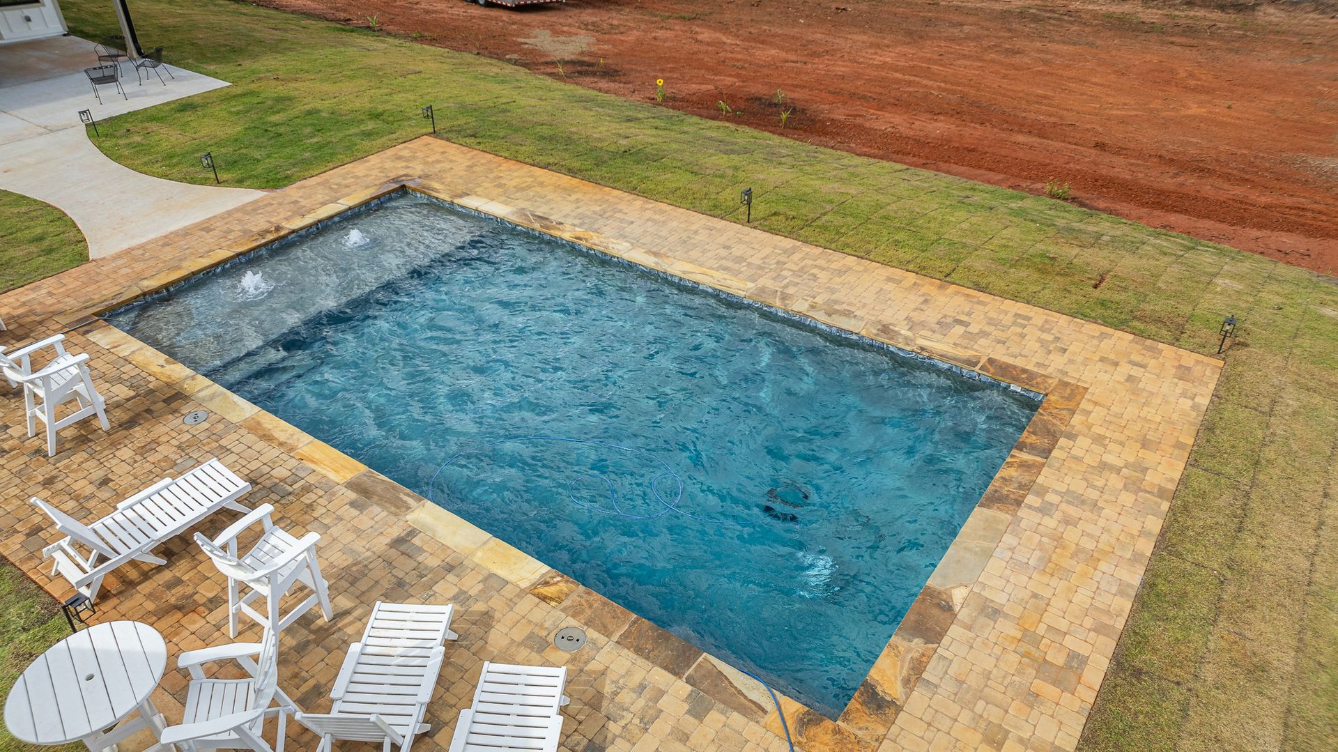 An aerial view of a swimming pool surrounded by chairs and tables.