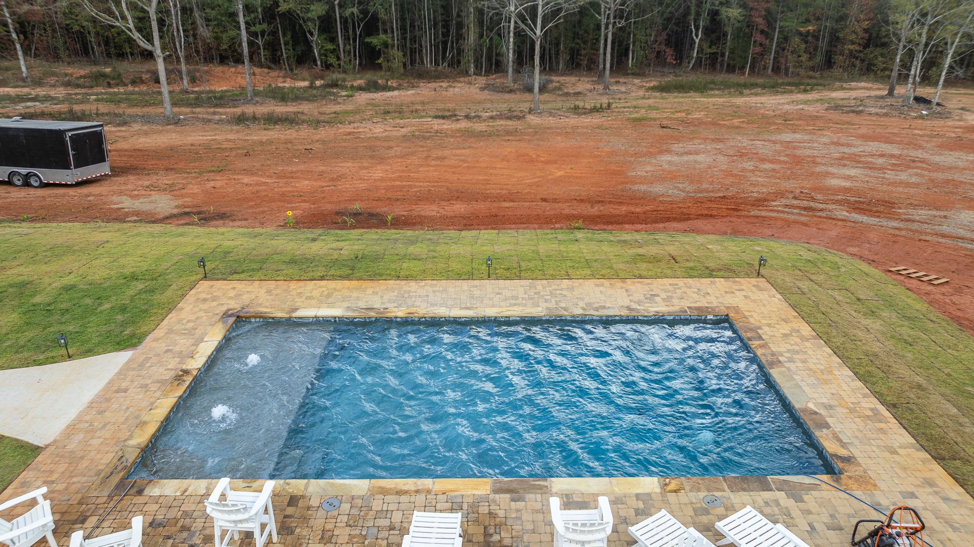 An aerial view of a large swimming pool surrounded by chairs and tables.