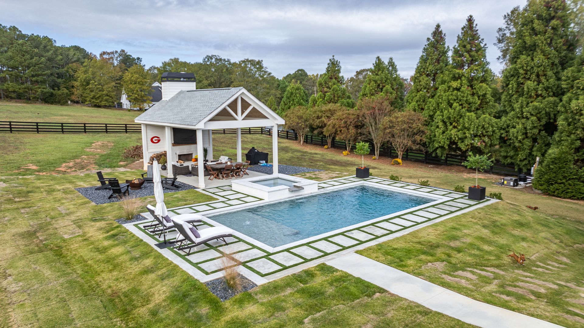 An aerial view of a large swimming pool with a gazebo in the background.