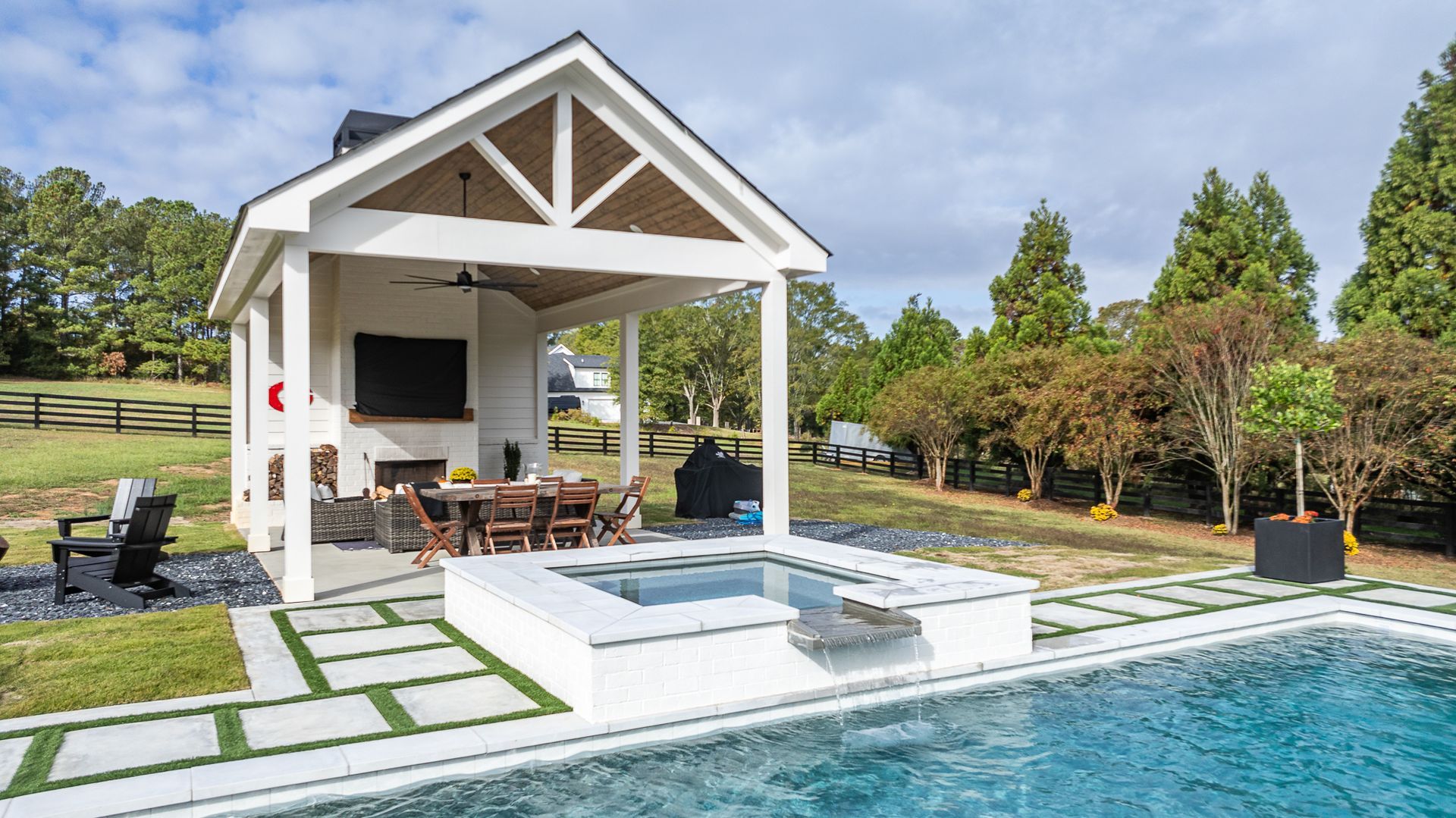 A large swimming pool with a gazebo and a hot tub in the backyard.