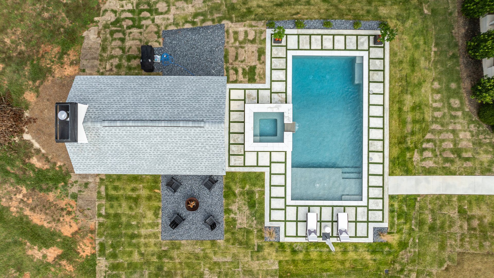 An aerial view of a house with a large swimming pool in the backyard.