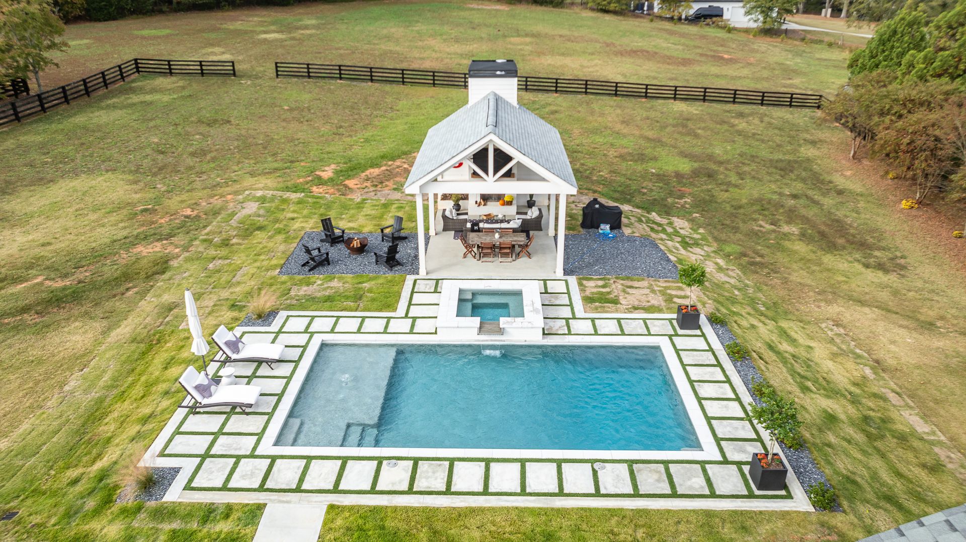 An aerial view of a large swimming pool with a gazebo in the background.