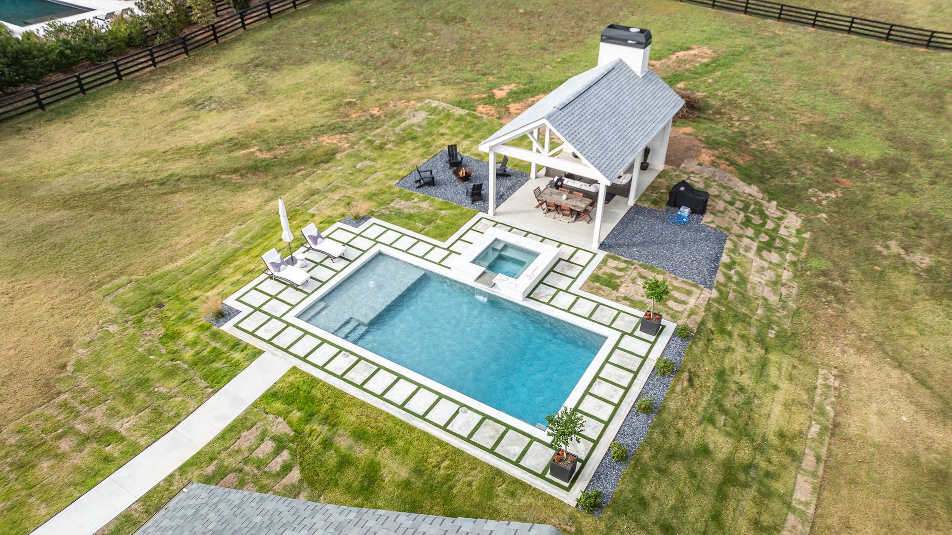 An aerial view of a large swimming pool with a gazebo in the backyard.