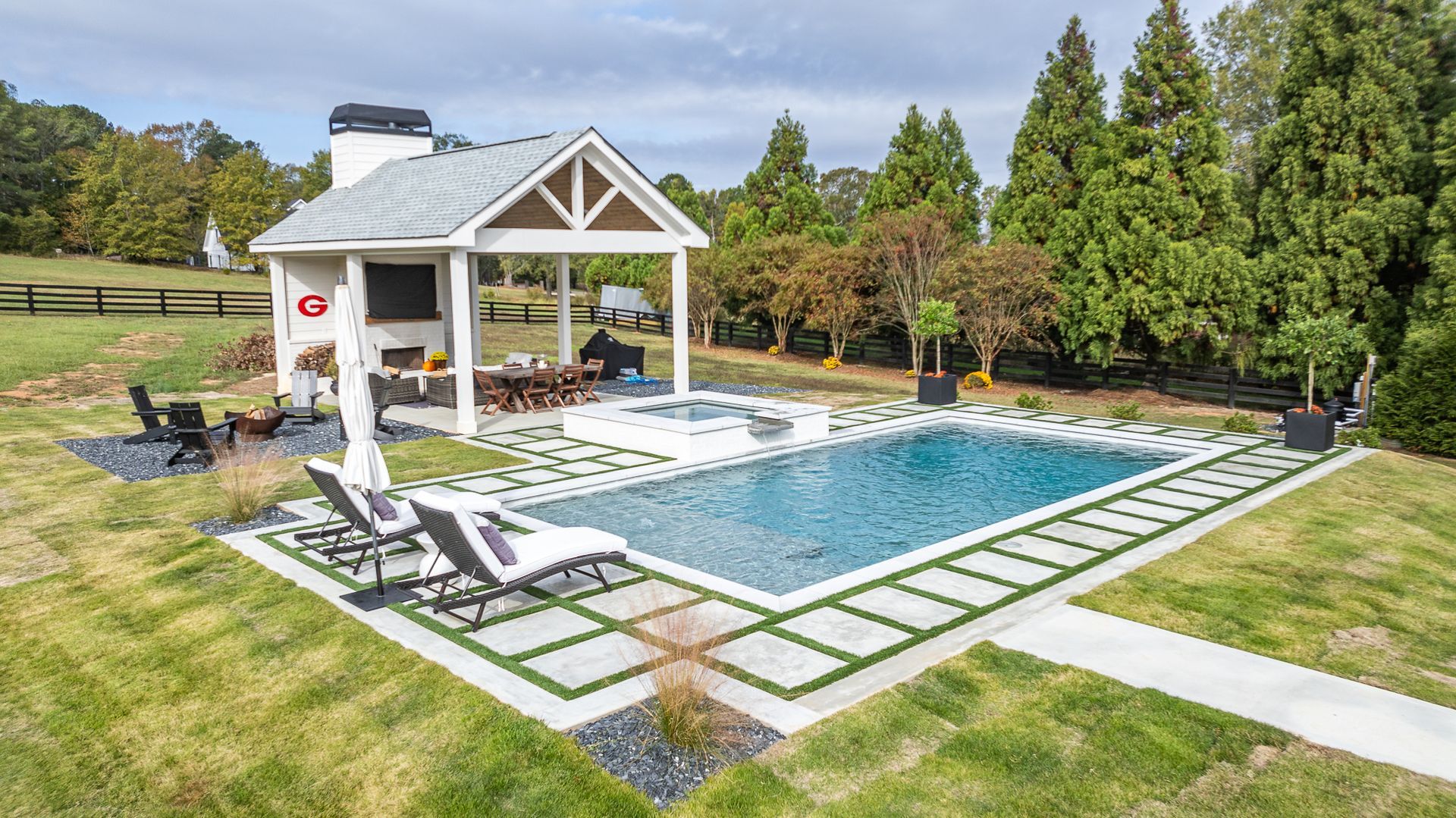 There is a large swimming pool in the backyard of a house.