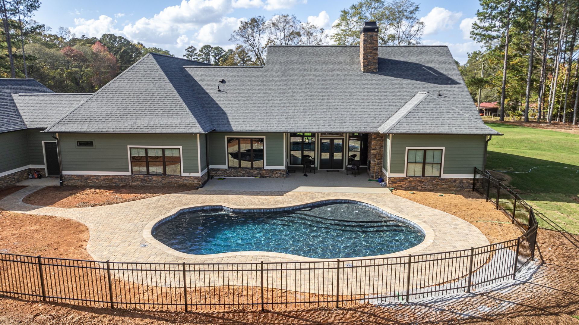 A large house with a large swimming pool in front of it