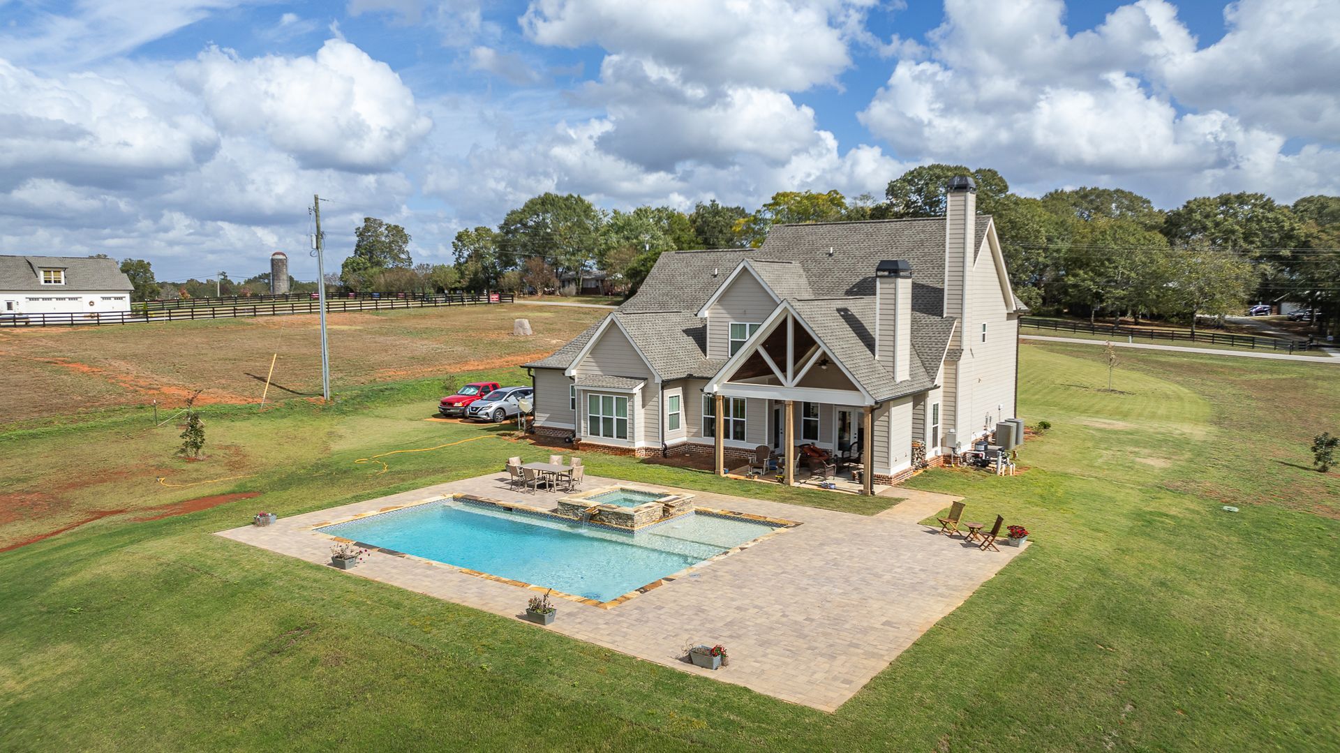 An aerial view of a house with a large swimming pool in the backyard.