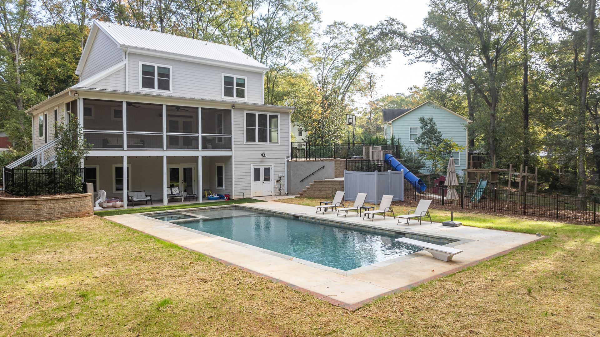 A large white house with a large swimming pool in the backyard.