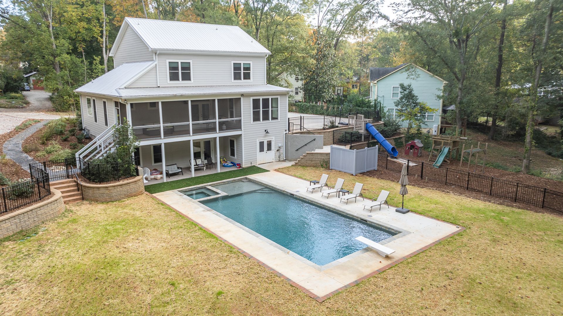 An aerial view of a house with a large swimming pool in the backyard.