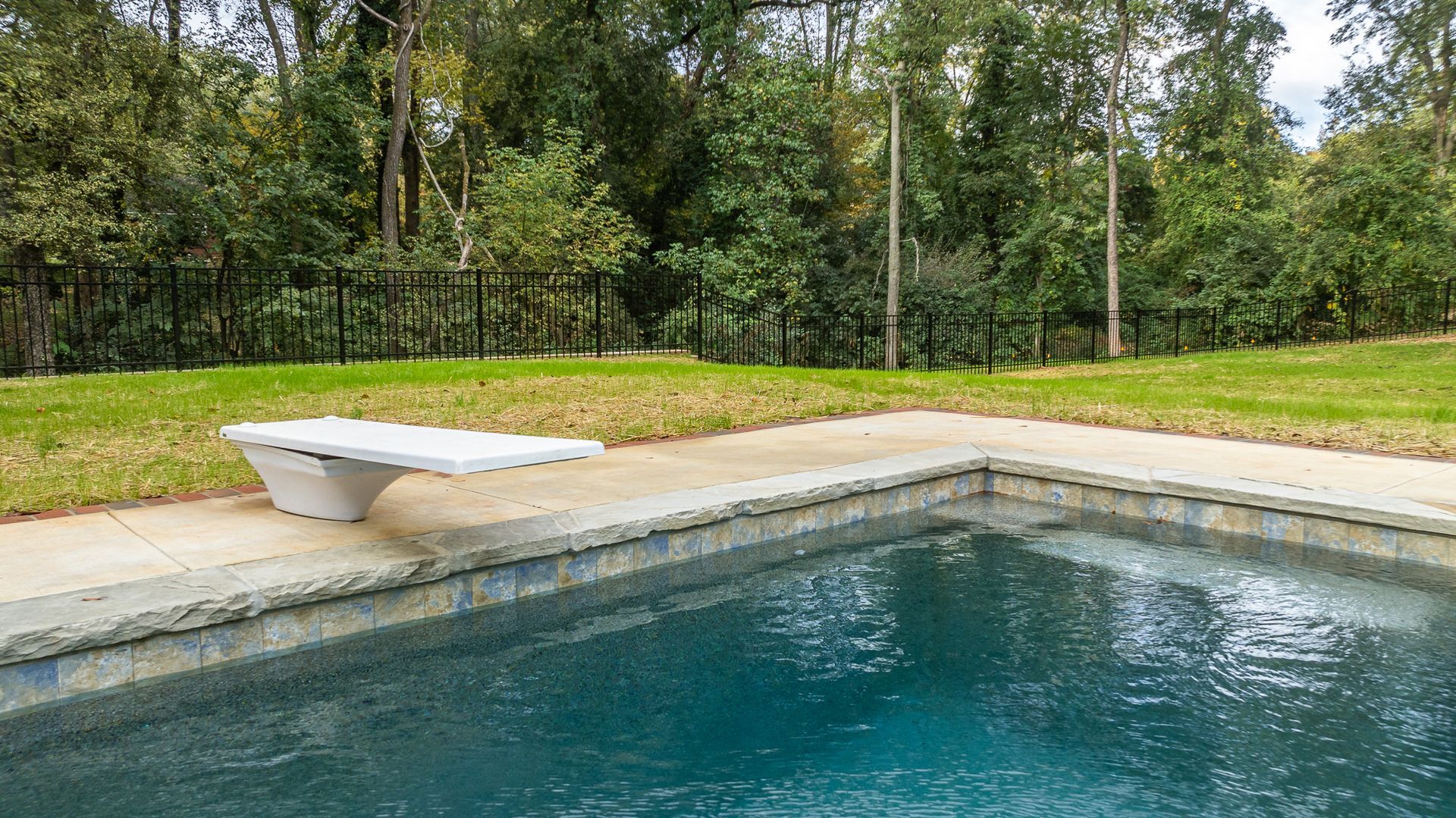 There is a diving board in the middle of the pool.