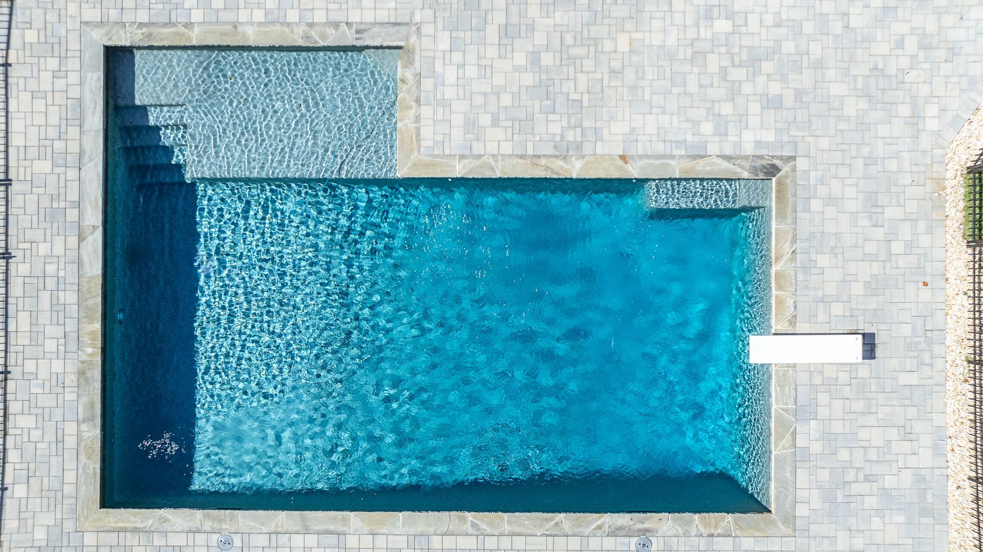 An aerial view of a large swimming pool surrounded by bricks.