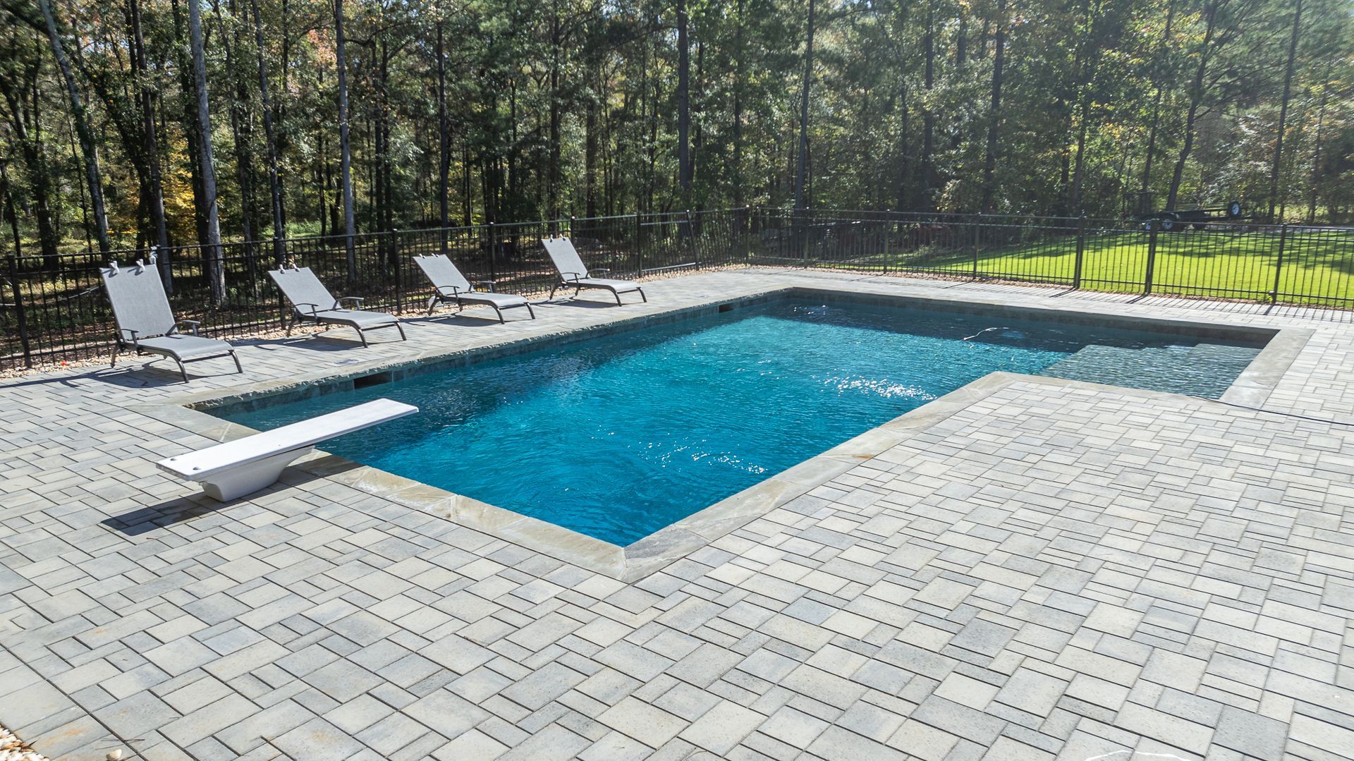 A large swimming pool with a diving board in the middle