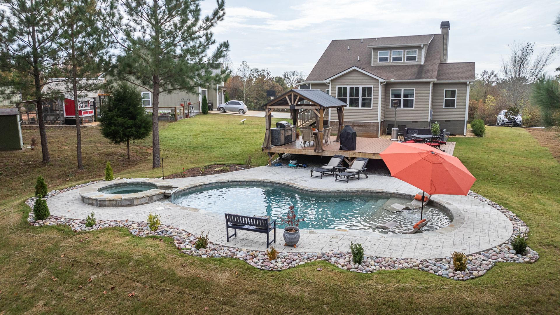 There is a large swimming pool in the backyard of a house.