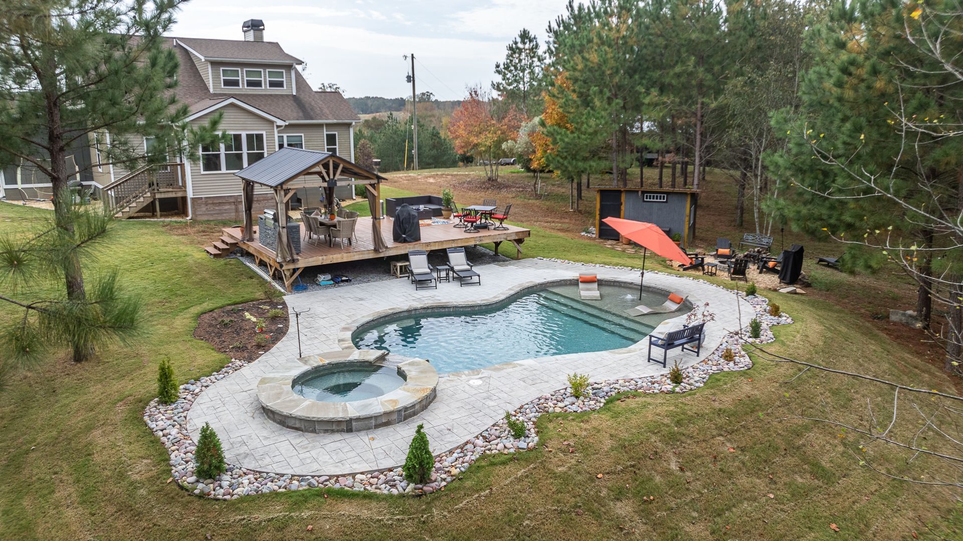 An aerial view of a house with a large swimming pool in the backyard.