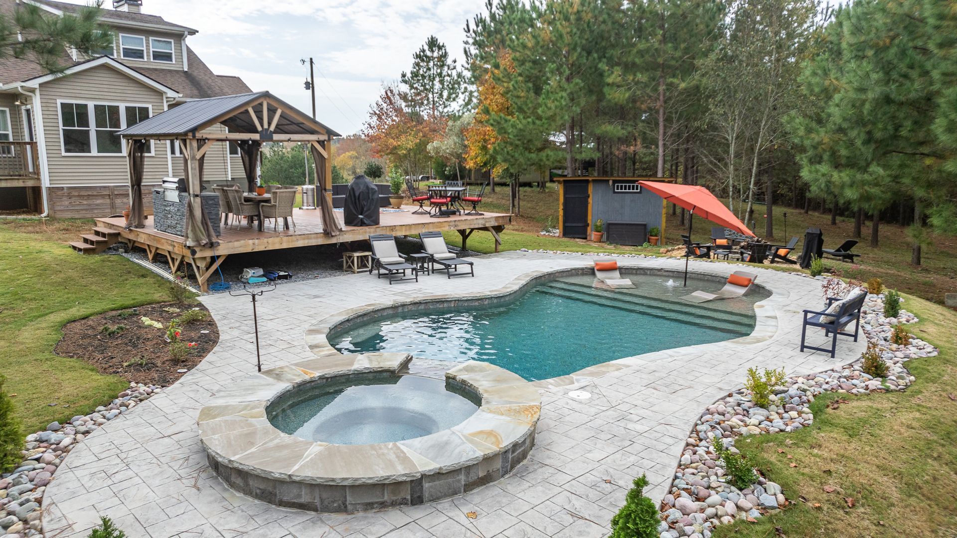 There is a large swimming pool and a hot tub in the backyard.