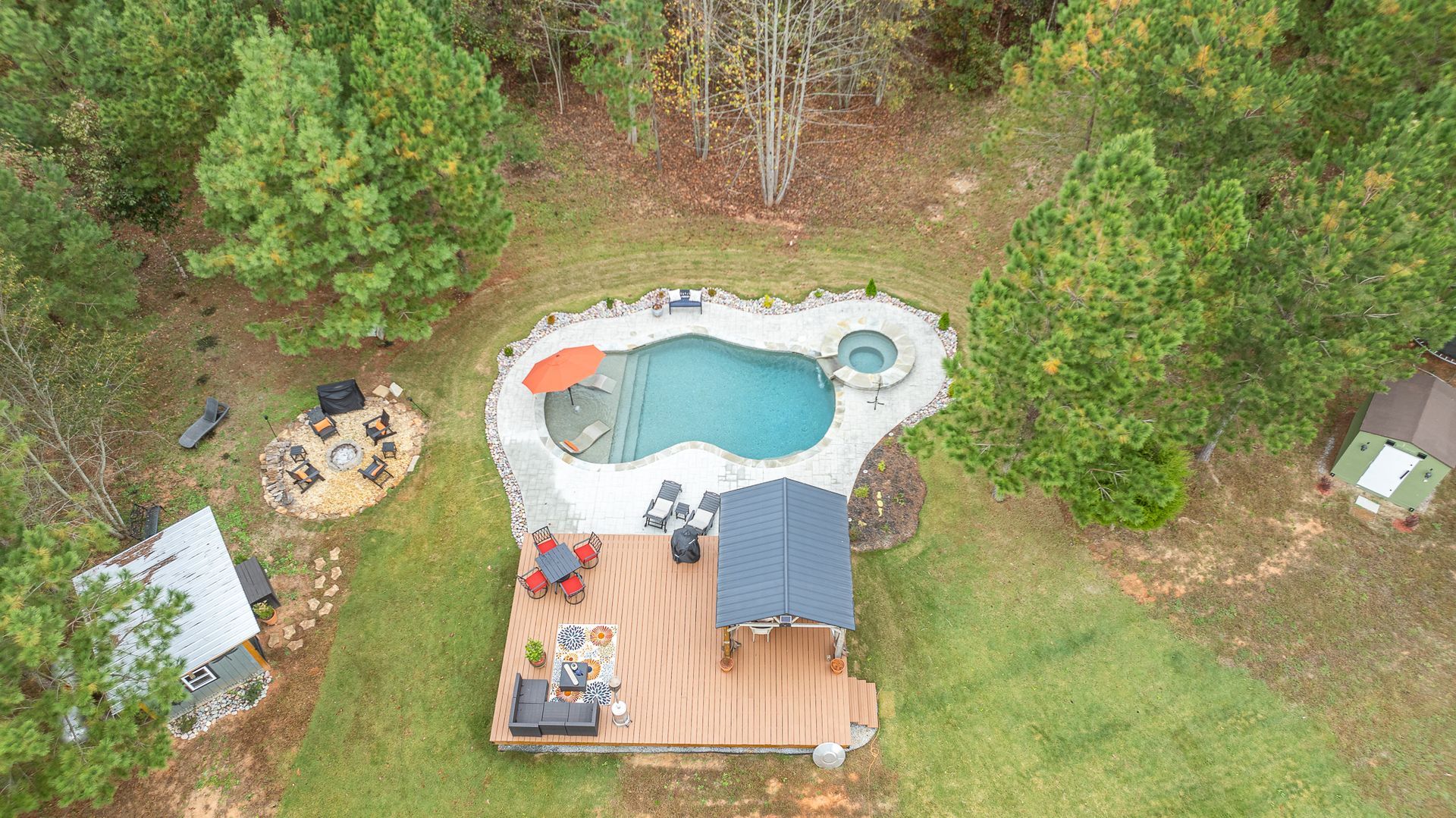 An aerial view of a backyard with a swimming pool and a deck.