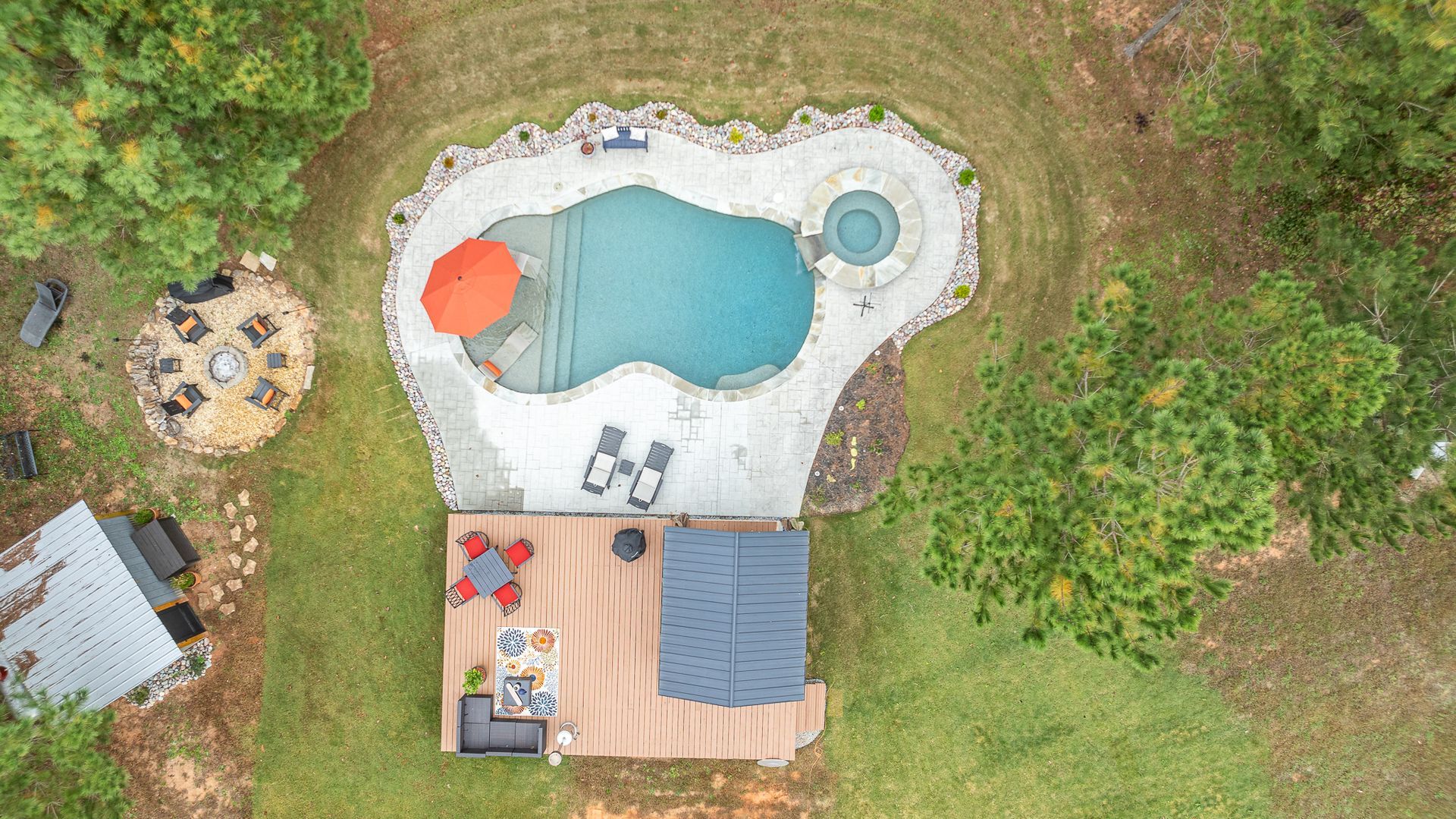 An aerial view of a backyard with a swimming pool and a hot tub.
