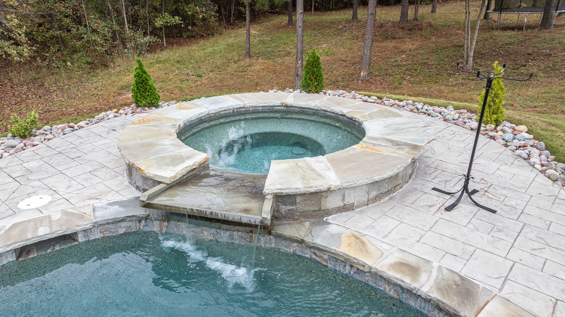 A swimming pool with a hot tub in the middle of it.
