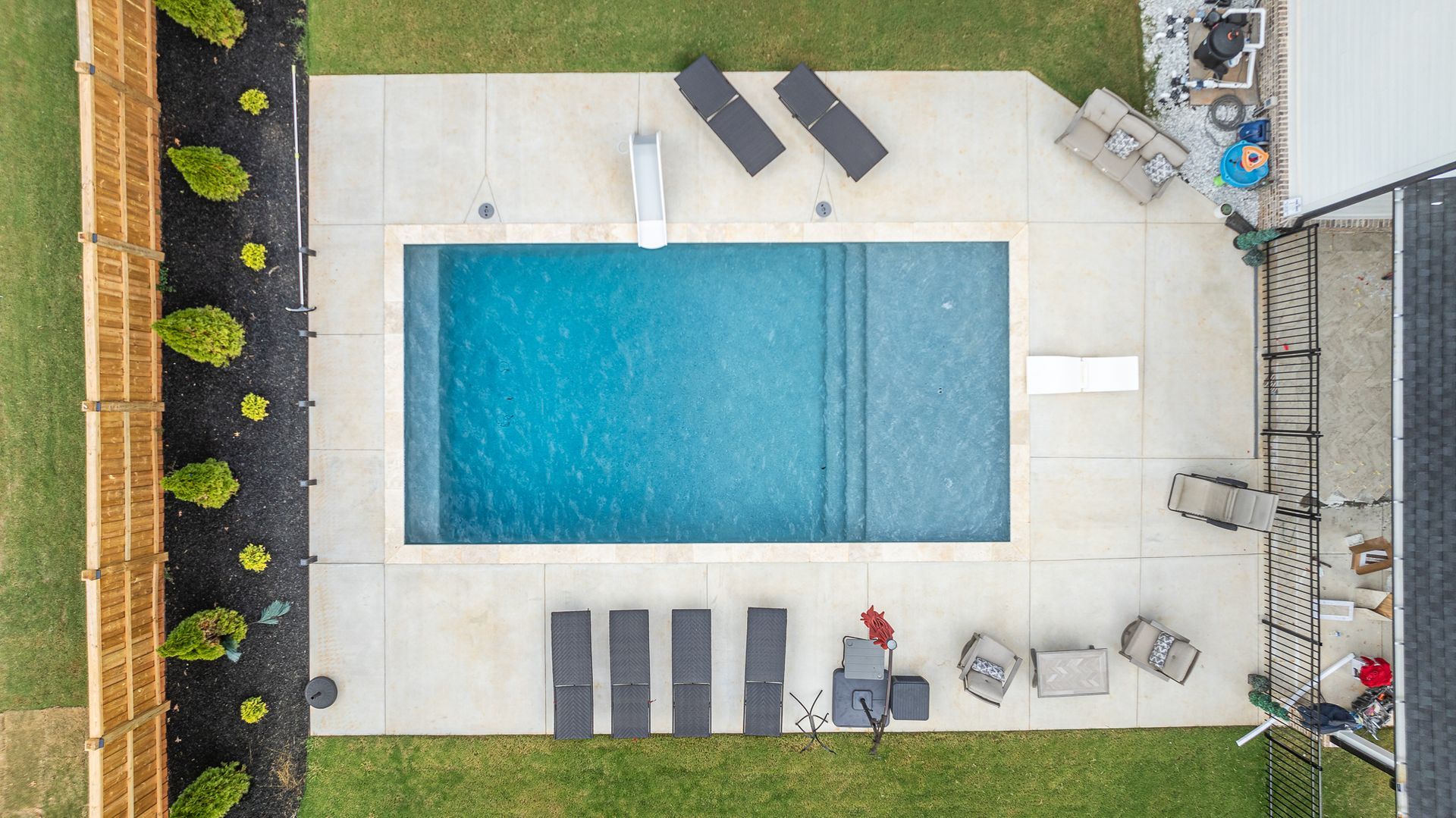 An aerial view of a large swimming pool in a backyard.