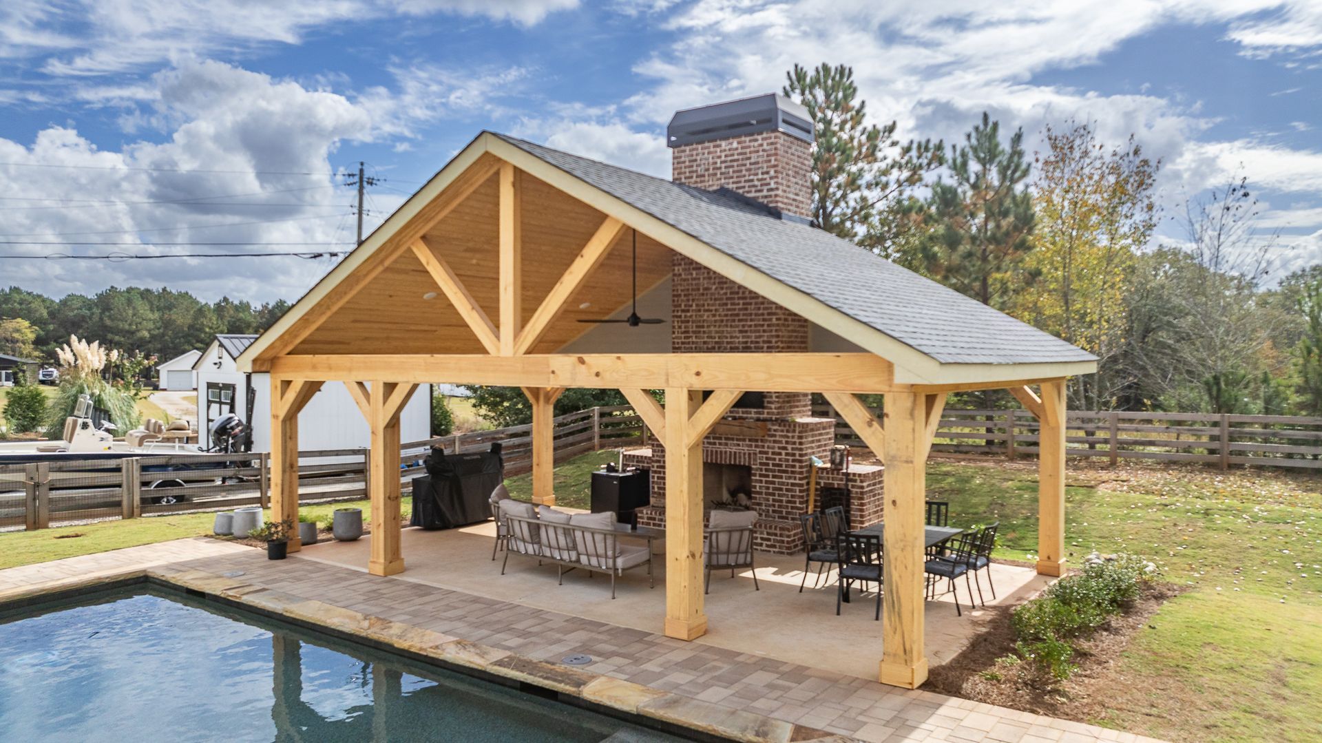 A large wooden pavilion is sitting next to a swimming pool.